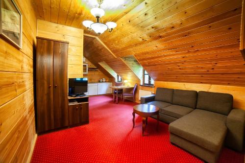 a living room with a couch and a table at Hotel Dworek Wapionka in Górzno