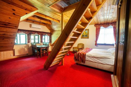 a bedroom with a bed and a staircase in a room at Hotel Dworek Wapionka in Górzno