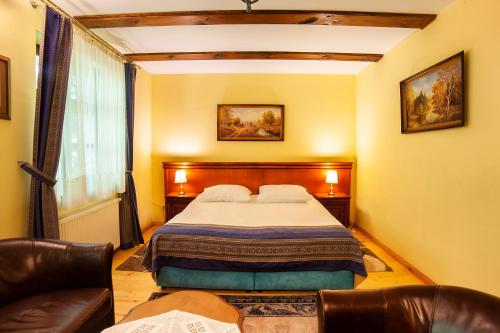 a bedroom with a bed and a couch and a window at Hotel Dworek Wapionka in Górzno