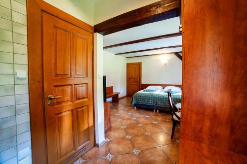 a bedroom with a bed and a wooden door at Hotel Dworek Wapionka in Górzno