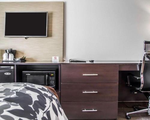 a bedroom with a desk with a tv and a bed at Sleep Inn & Suites Blackwell I-35 in Blackwell