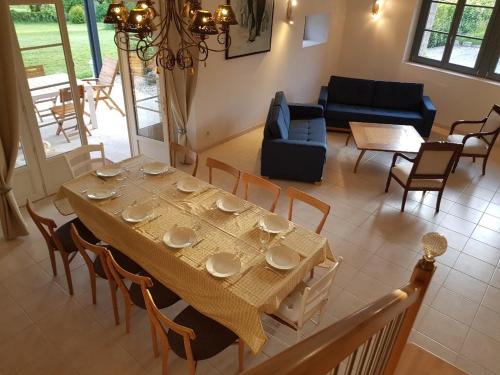 a dining table and chairs in a living room at VILLA CHAMPAGNE in Colombey-les-deux-Églises
