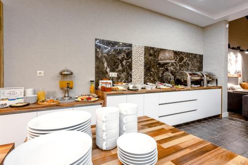 a kitchen with white stools and a counter with food at Hotel Tsiga in Gudauri