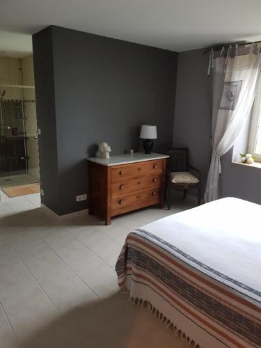 a bedroom with a bed and a dresser and a window at VILLA CHAMPAGNE in Colombey-les-deux-Églises