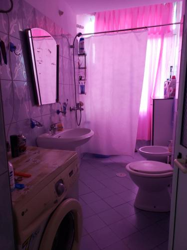 a bathroom with a sink and a toilet and a mirror at Malsi 2 Bedrooms Apartment in Vlorë