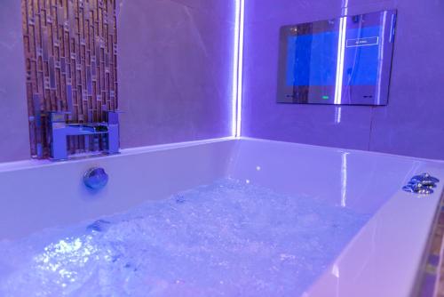 a bath tub filled with water in a bathroom at Meridian Serviced Apartments in Bradford