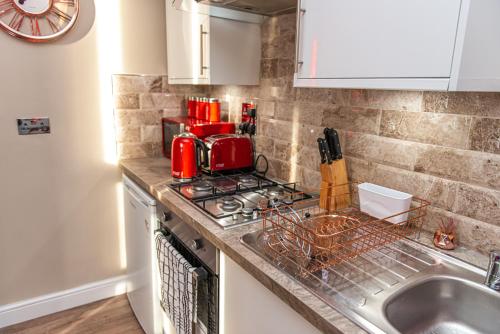 a kitchen counter top with a red appliance on it at Meridian Serviced Apartments in Bradford