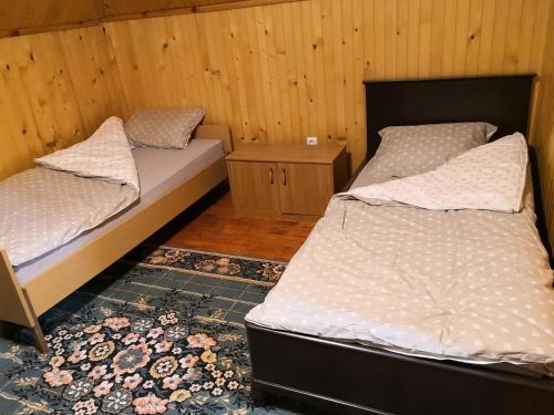 a room with two beds and a night stand and a bed sidx sidx sidx sidx at Vikendica Ajla in Travnik