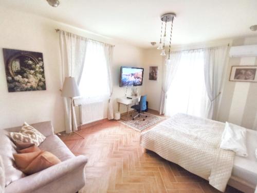 um quarto com uma cama, um sofá e janelas em Bellevue Apartment with AC & heating & terrace em Budapeste