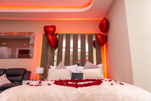 a bedroom with a bed with red heart balloons at Meridian Serviced Apartments in Bradford