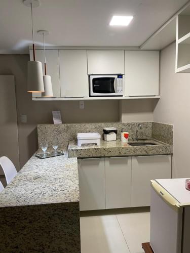uma cozinha com armários brancos e uma bancada em Flat Beira Mar de Tambaú apto 206 em João Pessoa