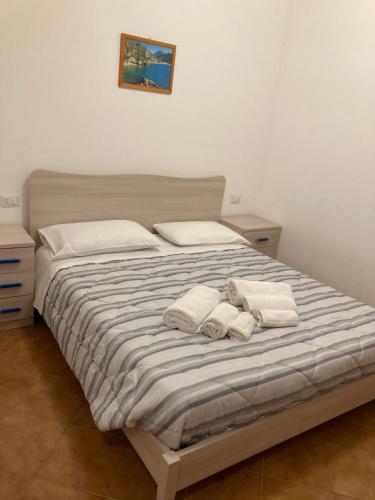 una camera da letto con un letto e due asciugamani di La Casa di Lulu' a Palinuro