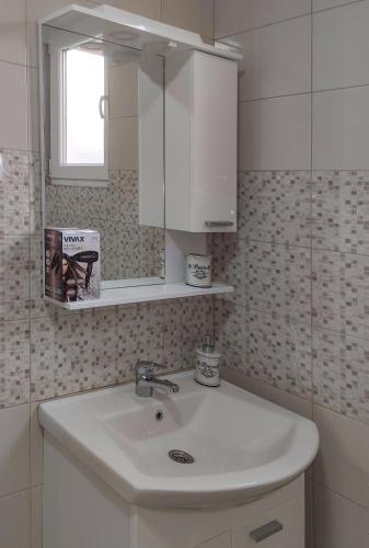 a bathroom with a white sink and a mirror at Apartmani Hani in Trebinje