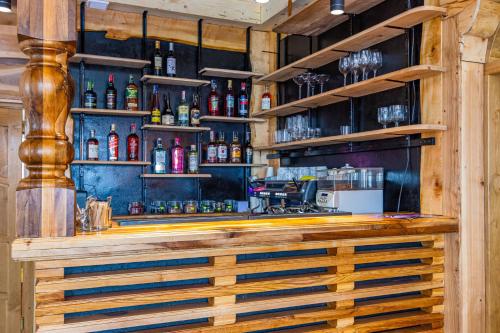 a wooden bar with alcohol on the shelves at Rich OAK - готель з відкритим панорамний басейном in Yablunytsya