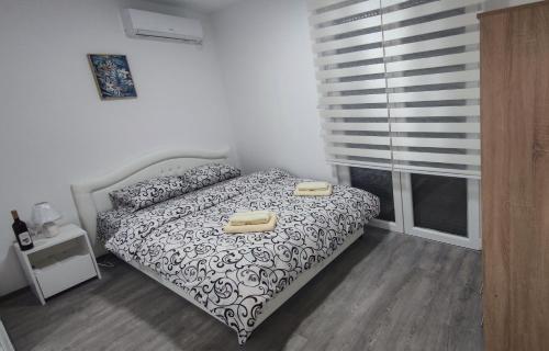 a bedroom with a bed with two towels on it at Apartmani Hani in Trebinje