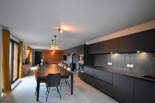 une cuisine et une salle à manger avec une table et des chaises dans l'établissement VAUJANYLOCATIONS - Marguerite, à Vaujany