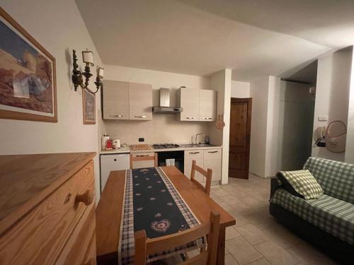 a kitchen with a table and a dining room at Dolomiti House in Pinzolo