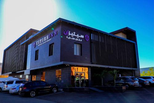 a building with cars parked in front of it at سيتيز إن للشقق المخدومة in Yanbu