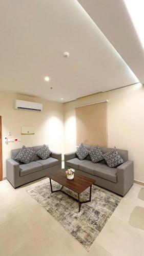a living room with two couches and a coffee table at سيتيز إن للشقق المخدومة in Yanbu