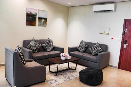 a living room with two couches and a coffee table at سيتيز إن للشقق المخدومة in Yanbu