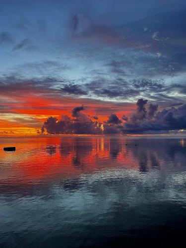 a sunset over a large body of water at Linareva Moorea Beach Resort in Haapiti