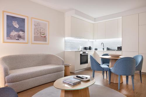 a living room with a couch and a table and chairs at Catarina Serviced Apartments in Porto