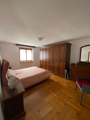 1 dormitorio con 1 cama y suelo de madera en Chez Carlo, en Aosta