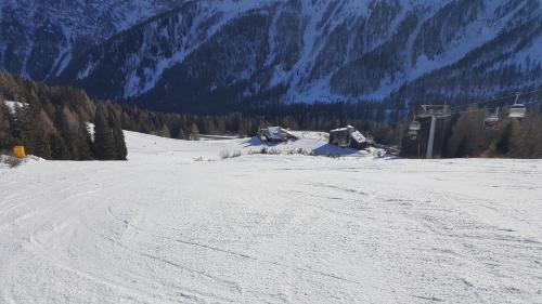 a snow covered slope with a ski lift in the distance at Casa AQ28 sulle piste da sci in Falcade