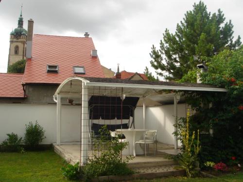 a pergola with a table and chairs in a backyard at Dům V Podzámčí in Mělník