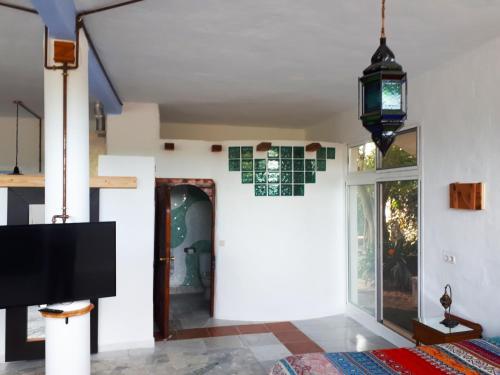 a living room with a tv and a window at Mi Cachito in Los Caños de Meca