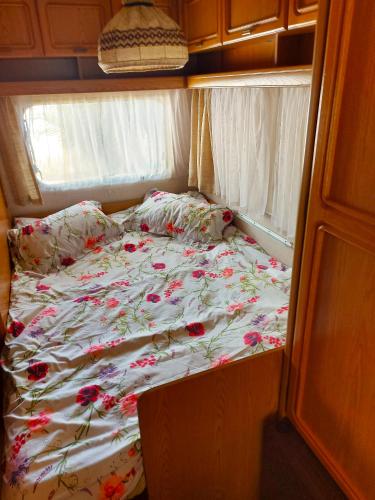 a bed in an rv with flowers on it at Mi Cachito in Los Caños de Meca