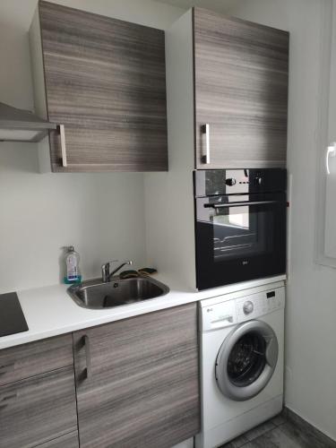 a kitchen with a sink and a microwave and a dishwasher at F2 Rénové Centre de Haguenau in Haguenau