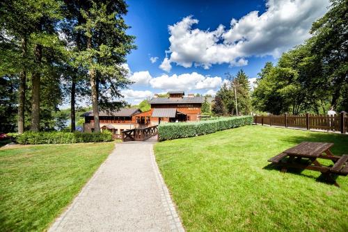 a house with a picnic table in the grass at Hotel Dworek Wapionka in Górzno