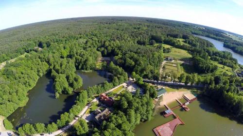 an aerial view of a lake with trees and a house at Hotel Dworek Wapionka in Górzno
