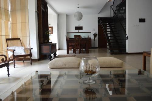 a living room with a wine glass on a glass table at Star Class Comfort in Capital City in Battaramulla