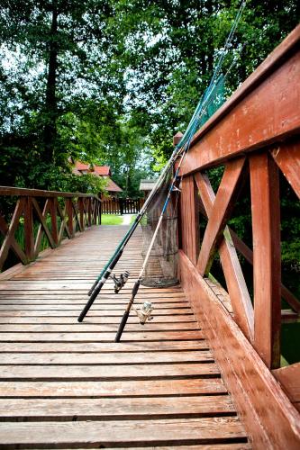 a wooden bridge with two birds on it at Hotel Dworek Wapionka in Górzno