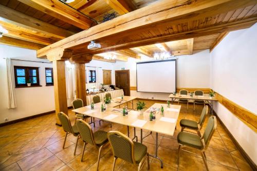 a conference room with tables and chairs and a whiteboard at Hotel Dworek Wapionka in Górzno