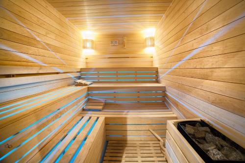 a sauna with wooden walls and benches in aermottermottermott at Hotel Dworek Wapionka in Górzno