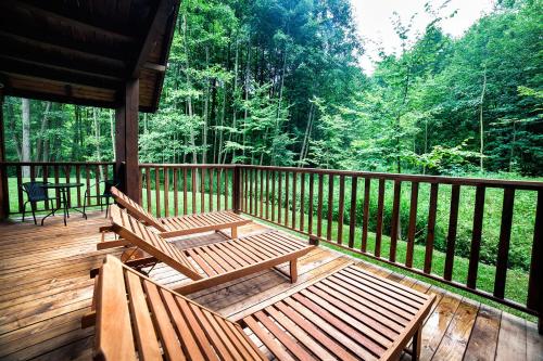 two benches sitting on a deck on a porch at Hotel Dworek Wapionka in Górzno