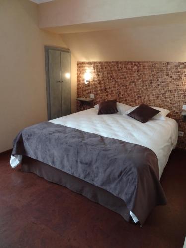 a large bed in a room with a brick wall at Merveilles88 in Rupt-sur-Moselle