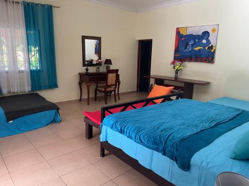 a bedroom with a bed and a table and a desk at Hacienda De La Bahia in Arroyo Barril