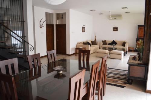 a living room with a glass table and chairs at Star Class Comfort in Capital City in Battaramulla