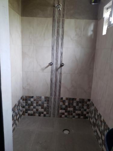 W łazience znajduje się prysznic ze szklanymi drzwiami. w obiekcie Hostal Pachamama w mieście San Agustín