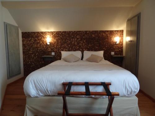 a bedroom with a large bed with a bench in it at Merveilles88 in Rupt-sur-Moselle