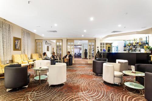 a lobby with tables and chairs and a bar at Mercure Maitland Monte Pio in Maitland