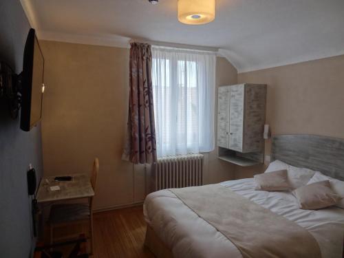 a bedroom with a bed and a window and a table at Merveilles88 in Rupt-sur-Moselle