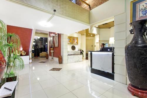 a lobby with a woman at a counter in a building at Mercure Maitland Monte Pio in Maitland