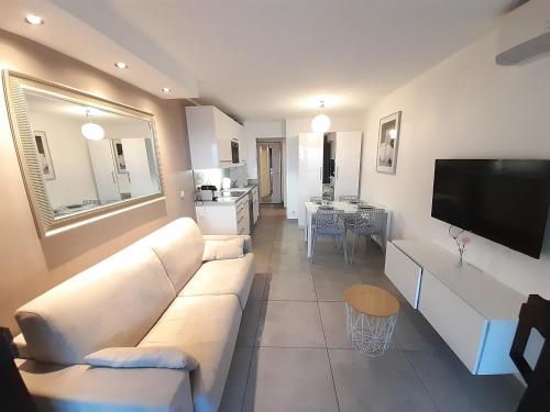 a living room with a white couch and a television at Cannes design vue mer in Cannes