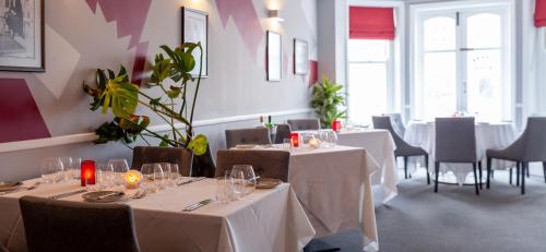 a restaurant with tables and chairs with white tablecloths at The Seaview Hotel And Restaurant in Seaview