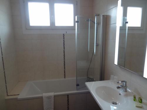 a bathroom with a bath tub and a sink at Merveilles88 in Rupt-sur-Moselle